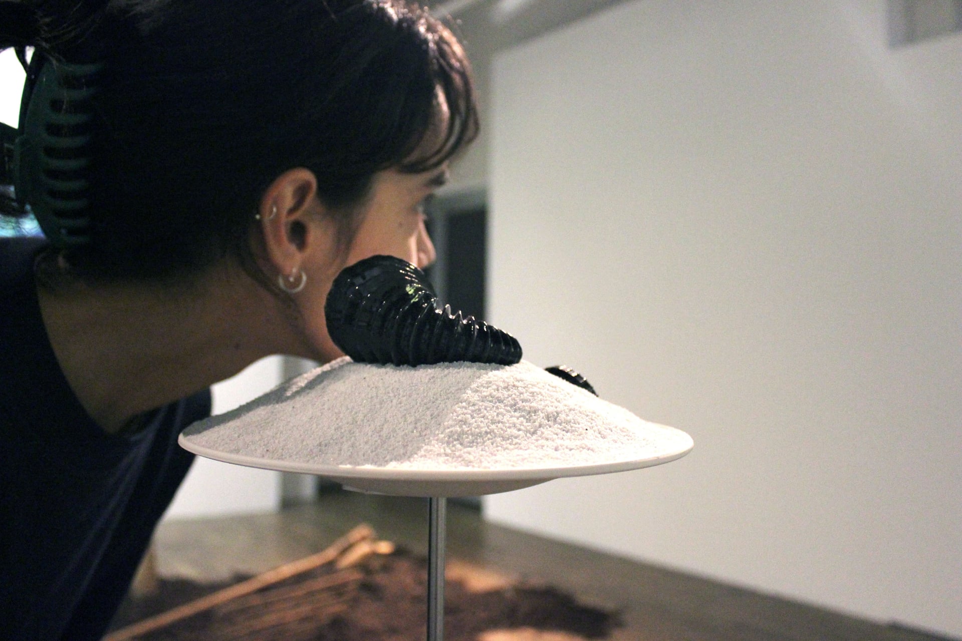 Une spectatrice écoute le son émis par le coquillage équipé d'un haut-parleur